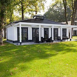 Mooi Zutendaal 4-persoons villa 4CE in Limburg, Belgie, omgeven door groene natuur en voorzien van een ruim terras voor ultiem buitenplezier.