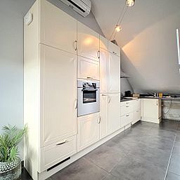 Moderne keuken in 't Vennehuisje, vakantiehuis in Genk, Limburg, Belgie met lichte kastdeuren en dakramen voor natuurlijk licht.