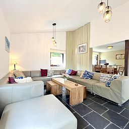 Gemuetliches Wohnzimmer des Ferienhauses Aux Hirondelles in Malmedy, Ardennen, mit grosser Sitzecke.