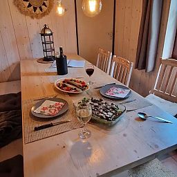 Gemuetlicher Essbereich im Chalet Pont du Waud in Waimes, Ardennen, Belgien, mit gedecktem Tisch und warmer Holzausstattung.