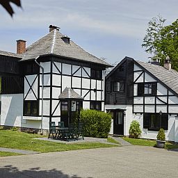 Gezellige eetruimte in Village les Gottales, 6-persoons bungalow in Trois-Ponts, Ardennen, met houten balken en uitzicht op de natuur.