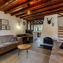 Gezellige woonkamer in Village les Gottales 6-persoons bungalow, Trois-Ponts, Ardennen, met houten balken en comfortabele banken.
