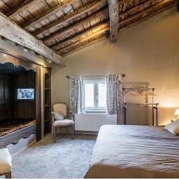 Cozy bedroom in Holiday Home Villa 'Marie France' Wellness, Stavelot, Ardennes, with authentic wooden interior and rustic ceiling.