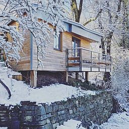 Schnee bedeckt die Huette in Comblain au Pont, einem charmanten Holzferienhaus in den winterlichen Ardennen, Luettich, Belgien.