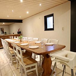 Gezellige eetkamer in vakantiehuis Annexe in Sourbrodt, Ardennen, Belgie, met lange houten tafel en comfortabele stoelen.