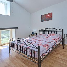 Gemuetliches Schlafzimmer im Ferienhaus "La Ferme" in Lierneux, Ardennen, Belgien. Helles Interieur mit Blick auf die gruene Umgebung.
