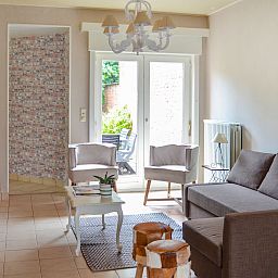 Gezellige woonkamer van Vakantiehuis Memories in Le Bizet, Henegouwen, Belgie, met comfortabele zitruimte en uitzicht op de tuin.