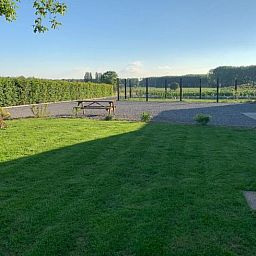 Ruime tuin met groen uitzicht bij Vakantiehuisje in Jollain, Henegouwen, ideaal voor ontspanning in de natuur.