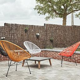 Modern terras met kleurrijke stoelen bij Vakantiehuisje in Jollain, Henegouwen, perfect voor buitenvermaak.