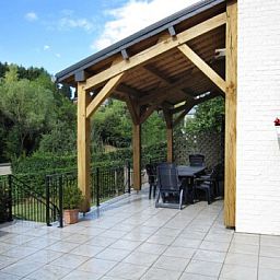 Overdekt terras bij Les Gronsarts Vencimont in de Ardennen, met uitzicht op de groene omgeving in Vencimont, Belgi.