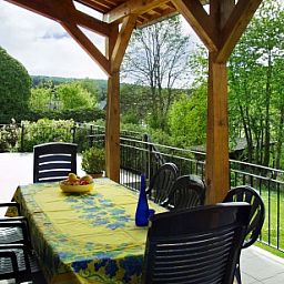 Gezellig eetgedeelte op de veranda van Les Gronsarts Vencimont vakantiehuis met uitzicht op de natuur in Vencimont, Belgi.