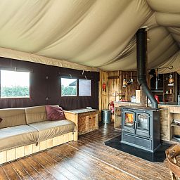 Gezellige binnenruimte van het Tenthuisje met warme privedouche in Vresse-sur-Semois, Ardennen. Comfortabele glamping lodge in Belgie.