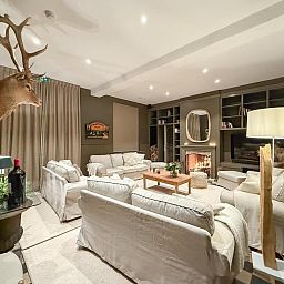 Gemuetliches Wohnzimmer im Ferienhaus "La Nouvelle Marquisette" in Houyet in den Ardennen mit bequemen Sofas und einem stimmungsvollen Kamin.