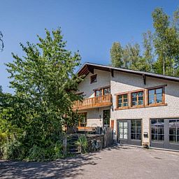 Enjoy the terrace of Leora Cosy vacation home in Membre, Ardennes, overlooking the green hills and an inviting garden.