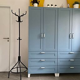 Stilvoller Innenraum im Ferienhaus Modernes Chalet in Heure, Ardennen, mit blauem Schrank und Garderobe fuer einen komfortablen Aufenthalt.