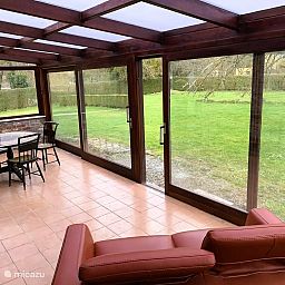 Veranda der Villa La Meuse - De Maas in Dinant, Ardennen, Belgien, mit Blick auf den gruenen Garten vom Ferienhaus aus.