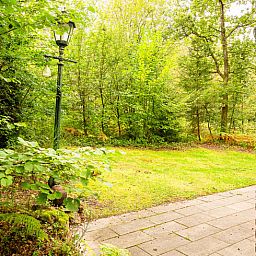 Gezellige woonkamer van Huisje in Izier, een vakantiehuis in de Ardennen, Belgie, met sfeervolle inrichting en uitzicht op de tuin.