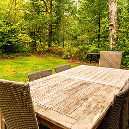Gezellige woonkamer in Huisje in Izier, een vakantiehuis in de Ardennen, Luxemburg, Belgie, met warme bakstenen muren en comfortabele zitruimte.