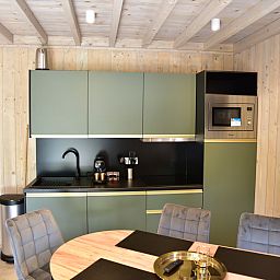 Modern kitchen in Ecolodge vacation home in Houffalize, Ardennes, Belgium, with stylish decor and comfortable dining area.