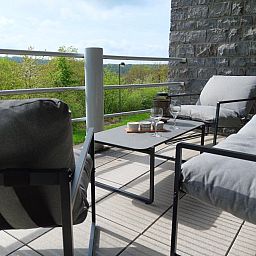 Gezellige woonkamer in vakantiehuis Castelgolf, Barvaux, Ardennen, met grote ramen en moderne inrichting voor een ontspannen verblijf.
