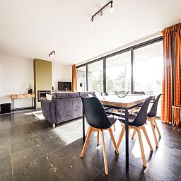 Gezellige woonkamer in vakantiehuis Castelgolf, Barvaux, Ardennen met moderne open haard en stijlvolle inrichting.