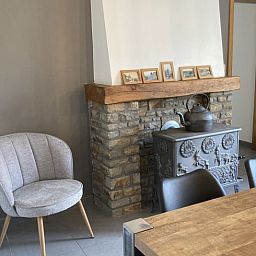 Gemuetliches Wohnzimmer im Cottage in Samree, Ardennen, mit rustikalem Kamin und bequemer Sitzecke.