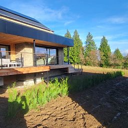 Veranda of Cottage in Grandmenil, located in Ardennes, Belgium, overlooking green nature and sunny garden.