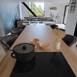 Cozy interior of Cottage in Grandmenil, vacation home in Ardennes, Belgium with modern kitchen and comfortable seating area.