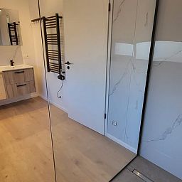 Modern bathroom in Cottage in Grandmenil, cottage in Ardennes, Belgium, with stylish wooden elements and spacious shower.