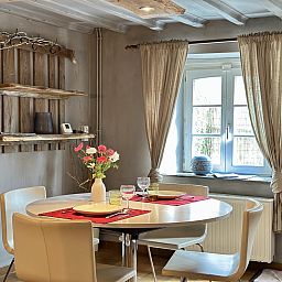 Gezellige eetkamer in Le Fournil vakantiehuis, Manhay, Ardennen, Belgie met rustieke houten accenten en uitzicht op de tuin.