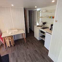 Binnenruimte van Coco Sweet met badkamer, een glamping lodge in La Roche-en-Ardenne, Ardennen, Belgie met moderne keuken en eethoek.