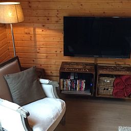 Cozy living room in Cottage in Erezee, Ardennes, Belgium with comfortable chair and modern television for relaxation.
