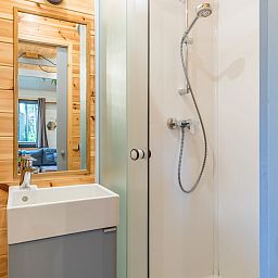 Moderne badkamer in 2-persoons tiny house 2BY in Poix-Saint-Hubert, Ardennen, Belgie, met houten afwerking en comfortabele douche.