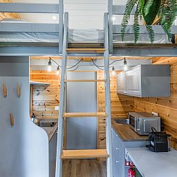 Knusse binnenruimte van 2-persoons tiny house 2BY in Poix-Saint-Hubert, Ardennen, met houten interieur en moderne keuken.