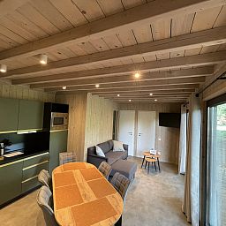 Gemuetlicher Innenbereich von Ecolodge I 3 Bedrooms, Ferienhaus in Bouillon, Ardennen, Belgien, mit moderner Kueche und geraeumiger Sitzecke.