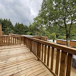 Geniessen Sie die Aussicht von der Holzterrasse der Ecolodge I 3 Bedrooms, einem Ferienhaus in Bouillon, Ardennen, Belgien.