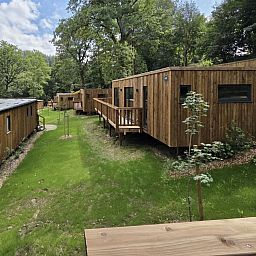 Ecolodge mit 2 Schlafzimmern in Bouillon, Ardennen, Belgien, umgeben von ueppiger Natur und mit einer einladenden Holzterrasse.