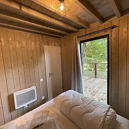 Gemuetliches Zimmer in Ecolodge mit Blick auf die Terrasse, in der natuerlichen Umgebung von Bouillon, Ardennen, Belgien.