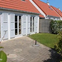 Geniet van de zonnige tuin en het terras bij Seaside Village, huisje 77, een charmant vakantiehuis in Vosseslag, De Haan, Belgische kust.