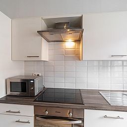 Moderne keuken van vakantiehuis Ijzerstraat - 52 in Blankenberge, Belgische kust, met inductiekookplaat en magnetron.