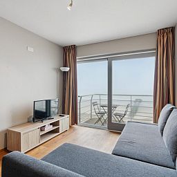 Lichte woonkamer van Ocean Suites - 1004 in Blankenberge, Belgische kust. Vakantiehuis met balkon en zeezicht voor een ontspannen verblijf.