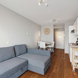Moderne woonkamer in Ocean Suites - 1004, vakantiehuis in Blankenberge aan de Belgische kust, met comfortabele zithoek en eetruimte.
