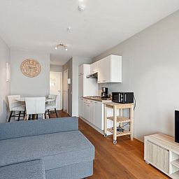 Gezellige woonkamer en keuken in Ocean Suites - 1004, vakantieappartement aan de Belgische kust in Blankenberge.
