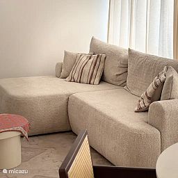 Cozy living room in the Let's Go Koksijde apartment on the Belgian coast, featuring a comfortable sofa and stylish decor.