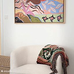 Stylish interior of the Let's Go Koksijde apartment on the Belgian coast, featuring modern artwork and a comfortable seating area.