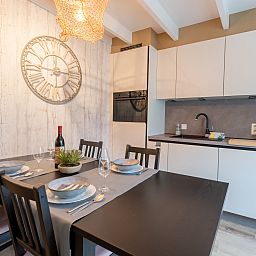 Gezellige eetruimte in Vakantiehuis Strandhuis, Bredene aan de Belgische kust, met moderne keuken en sfeervol gedekte tafel.