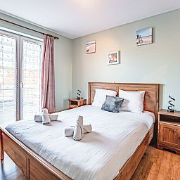 Cozy bedroom in the Zandloper Apartment with a balcony in Bredene on the Belgian coast, ideal for a relaxing stay.