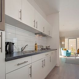 Modern kitchen in Chalet in Bredene, Belgian coast, Belgium, with bright decor and views of the sunny living room.