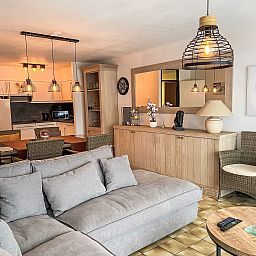 Cozy living room of Apartment 103 in Bredene, Belgian coast, with comfortable sitting area and modern kitchen.