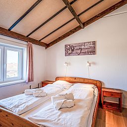 Cozy bedroom in Apartment Zeewind II A 11, Bredene on the Belgian coast, with rustic wooden interior and natural light.